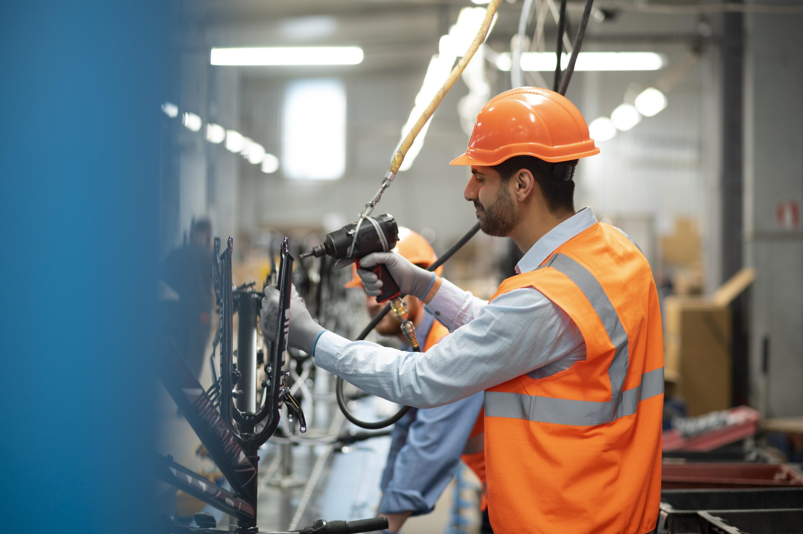 Technician in high-visibility clothing servicing equipment in a workshop